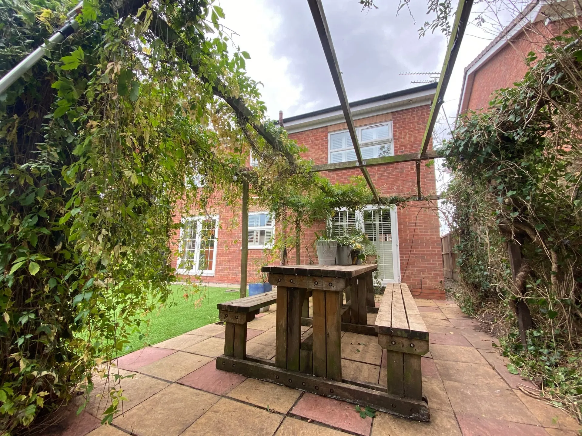 Opened-up pergola area after garden maintenance in Wistaston